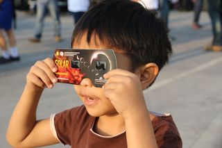 March 9, 2016: Thailand boy viewing a solar eclipse in Chiang Mai, Thailand.