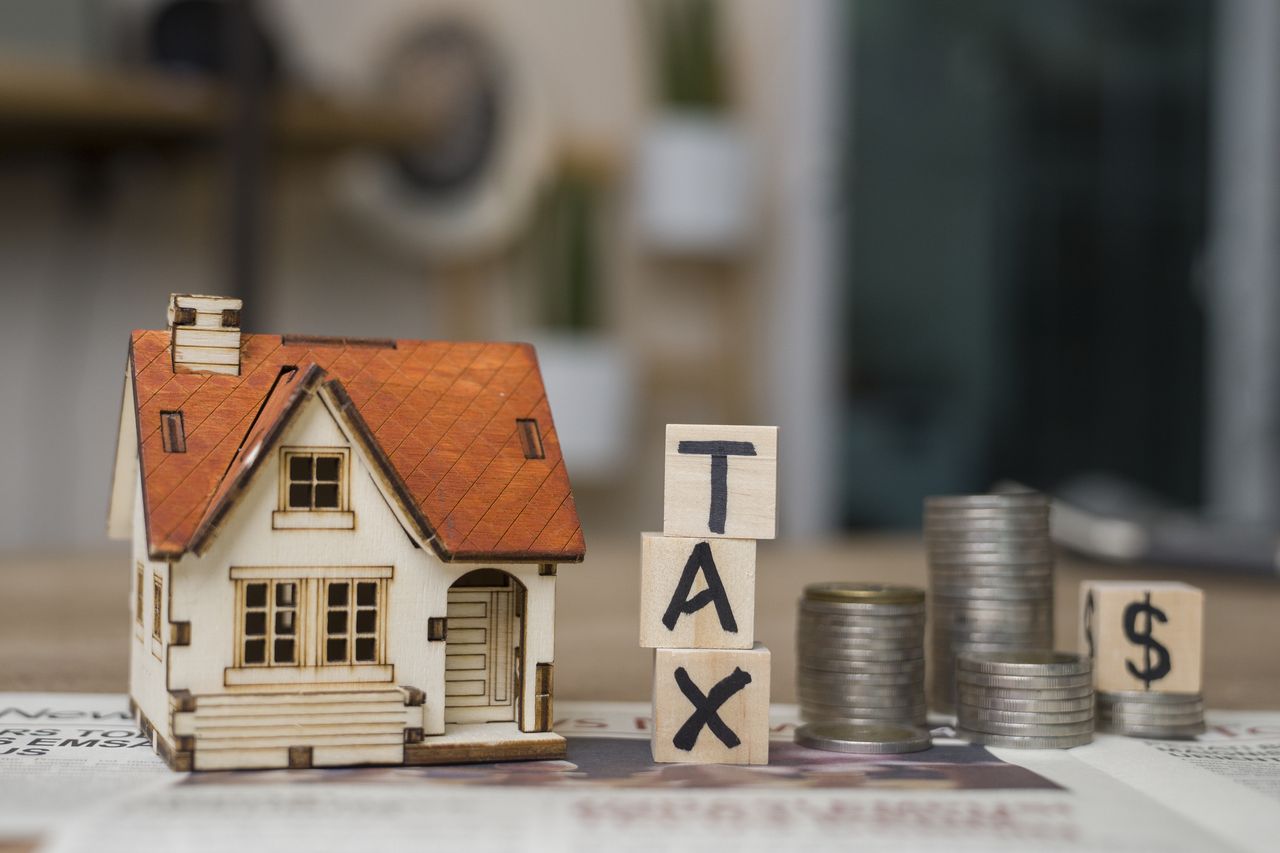 Tax text written on wooden block with stacked coins