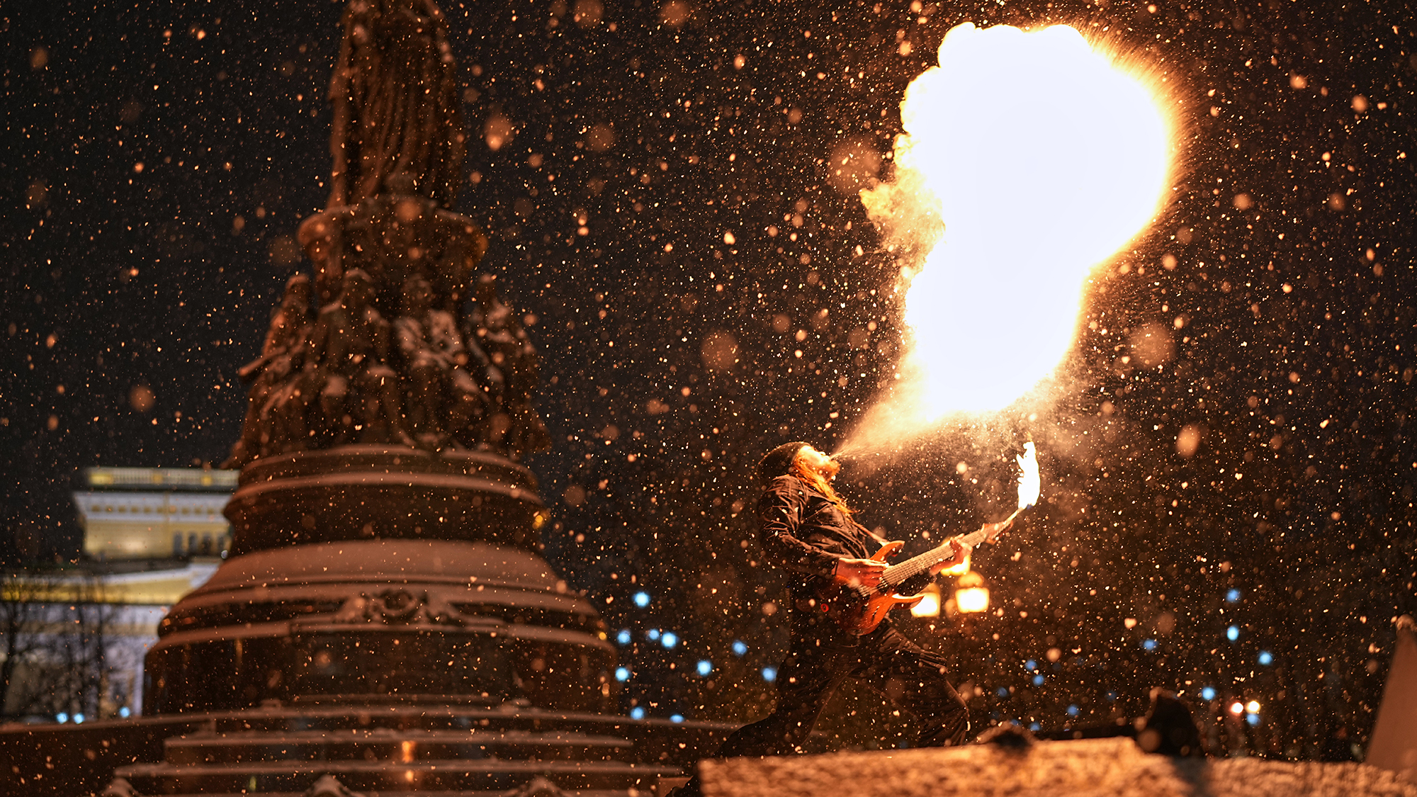 A street musician breathes fire during a heavy snowfall in St. Petersburg, Russia