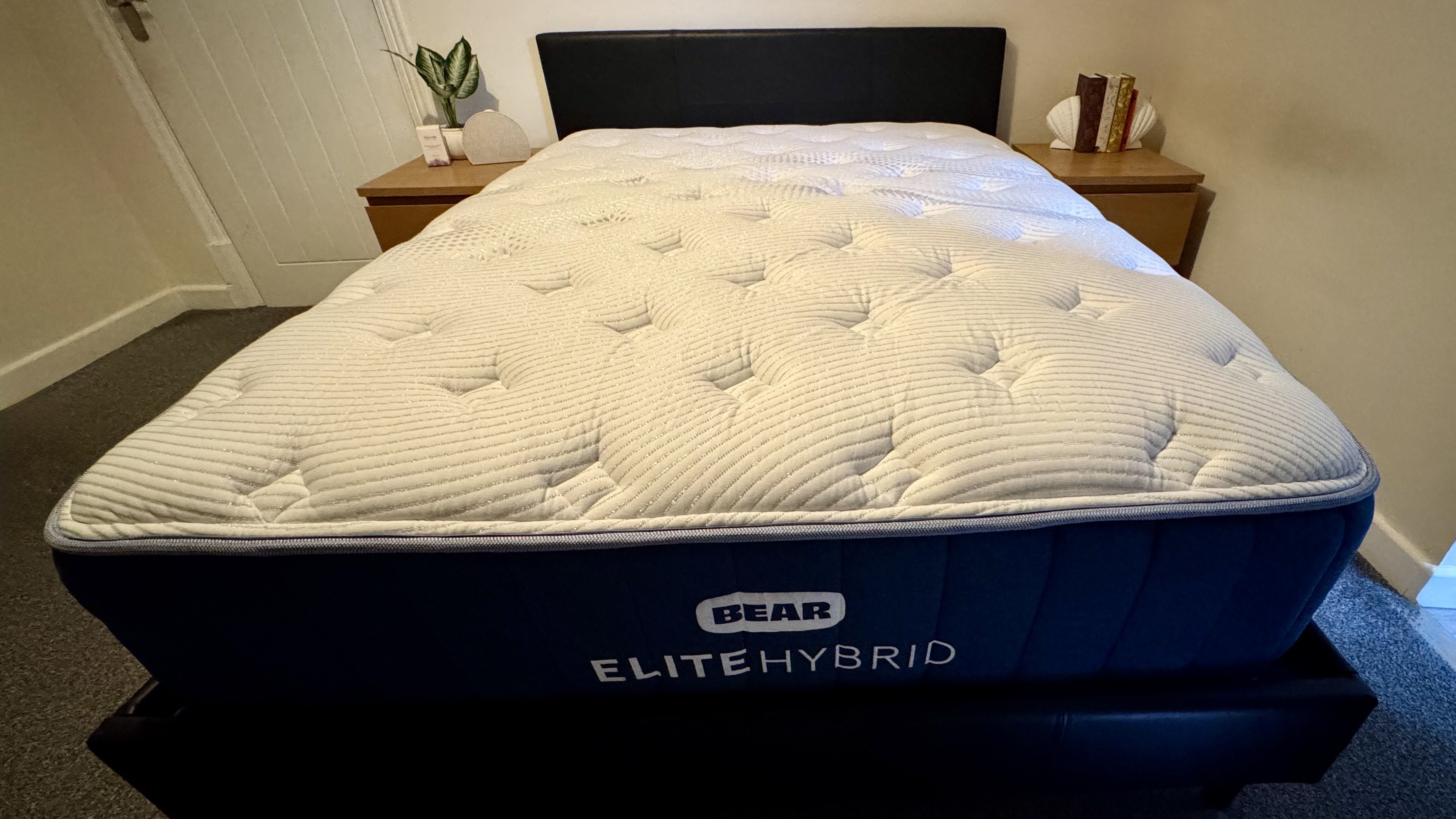 Bear Elite Hybrid Mattress on black bedframe in bedroom with two wooden bedside cabinets