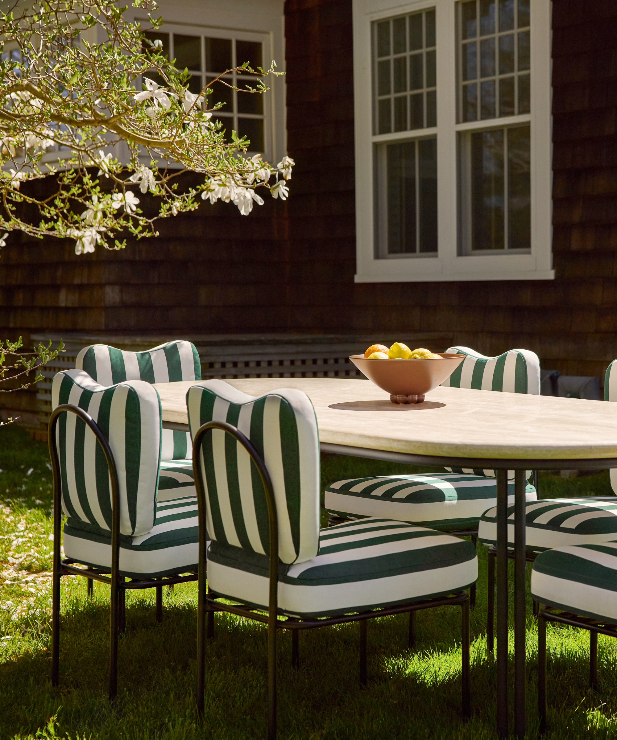 an outdoor dining area with green and white striped chairs