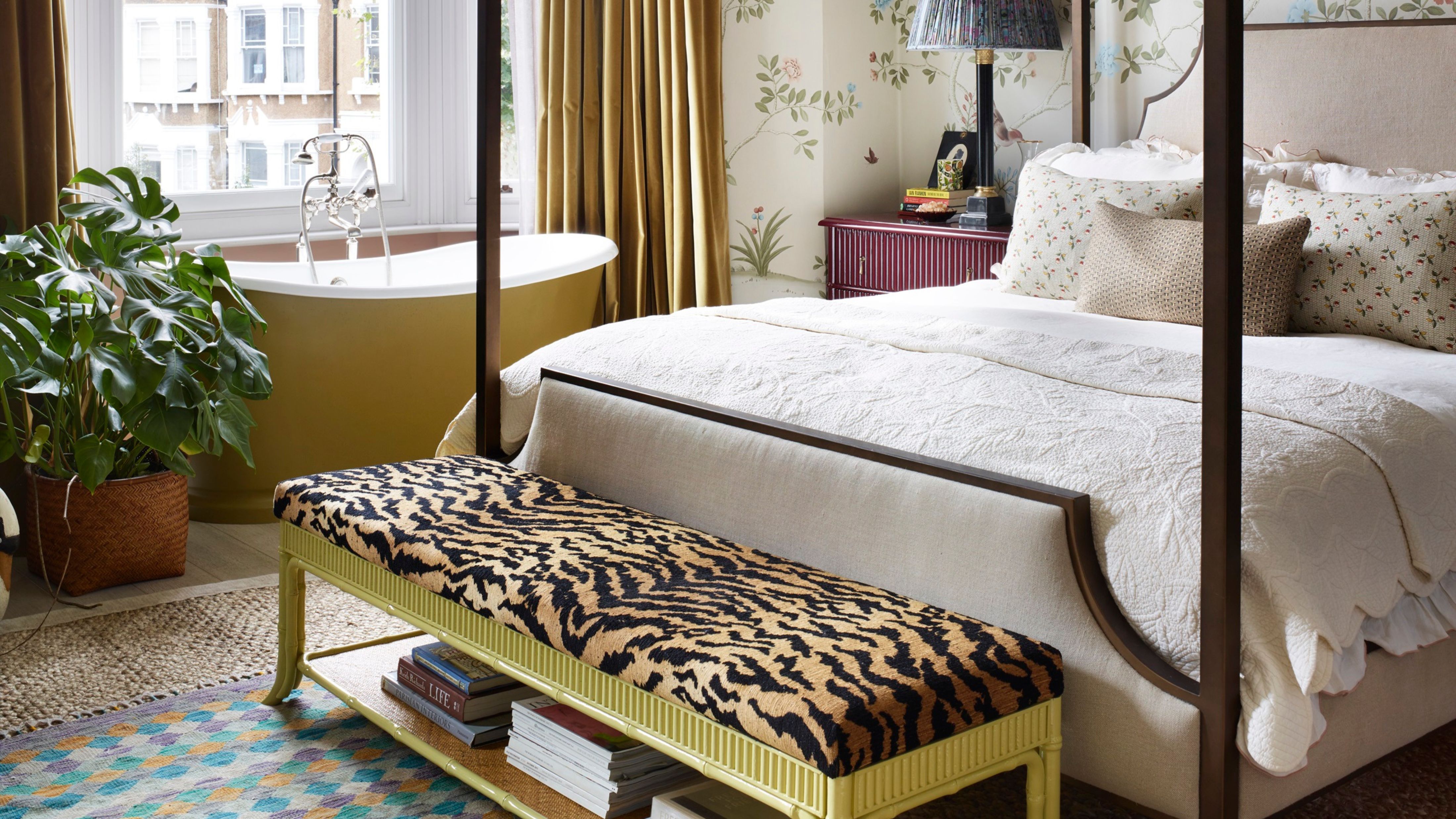 Sunlit townhouse bedroom featuring a tiger print storage bench sitting at the foot or a four-poster bed