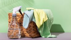 Microfiber cloths for cleaning and a spray bottle with clean water. Tools for eco friendly cleaning without household chemicals on a green background