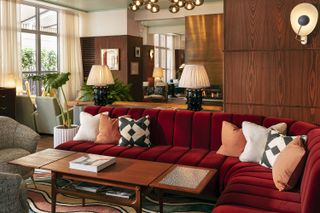 Wrap around red sofas and eclectic accessories in the lounge area at The Hoxton Rome