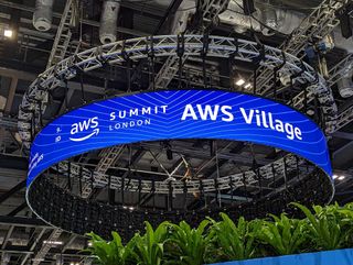 AWS Summit logo appearing on circular, ceiling-attached sign above the conference floor