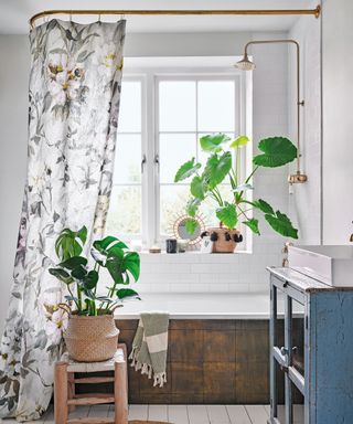 bathroom with white wall and pots and bathtub