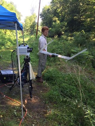 Sam Fabian, a doctoral student at the University of Cambridge, readies the 'fly teaser' for a high-speed video shoot of robber fly antics.