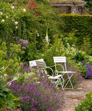 Garden furniture in white amongst flower beds