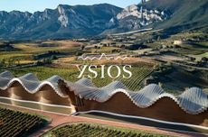 Ysios winery with mountains in the background and Ysios logo in white over the top