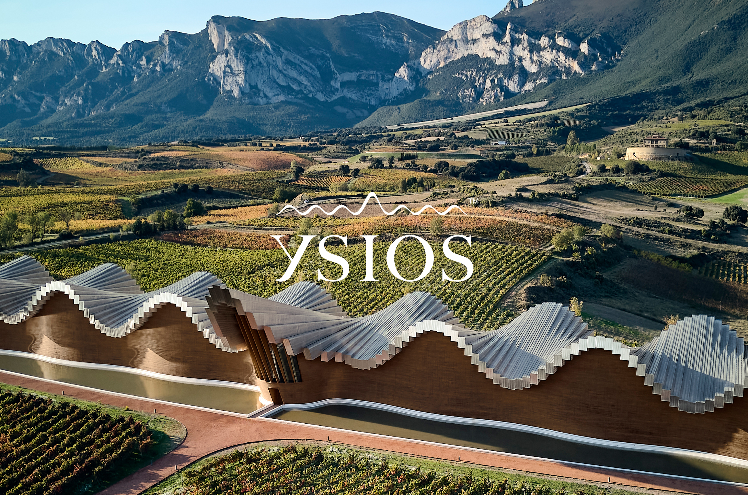 Ysios winery with mountains in the background and Ysios logo in white over the top