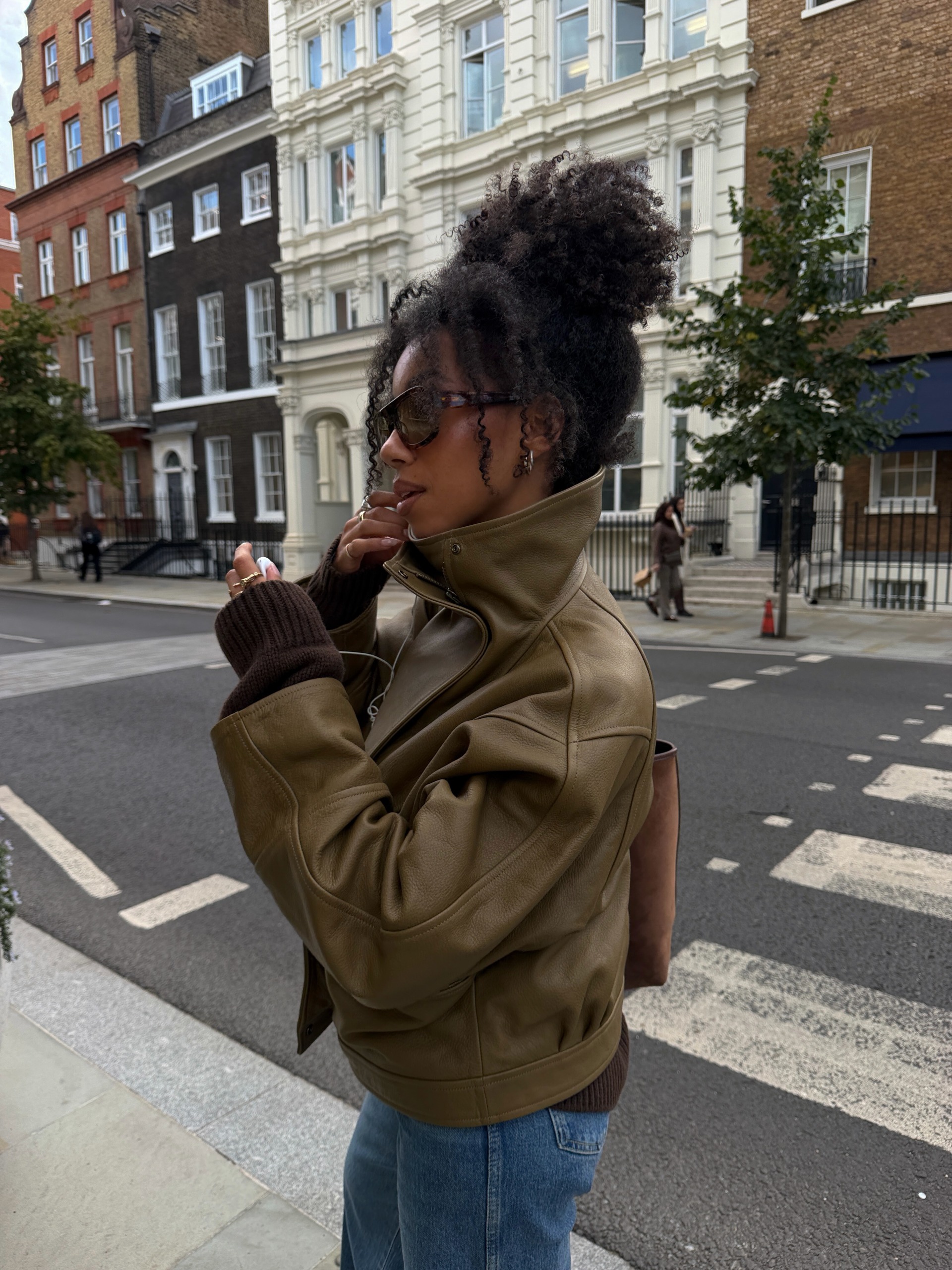autumn 2026 cult buys: Amaka Hamelijnck wears a khaki green leather jacket with a stand collar and blue jeans