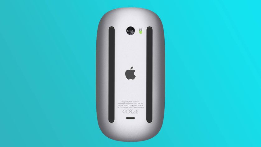 The underside of the Apple Magic Mouse showing the bad placement of the USB Type-C port, on a light blue gradient background