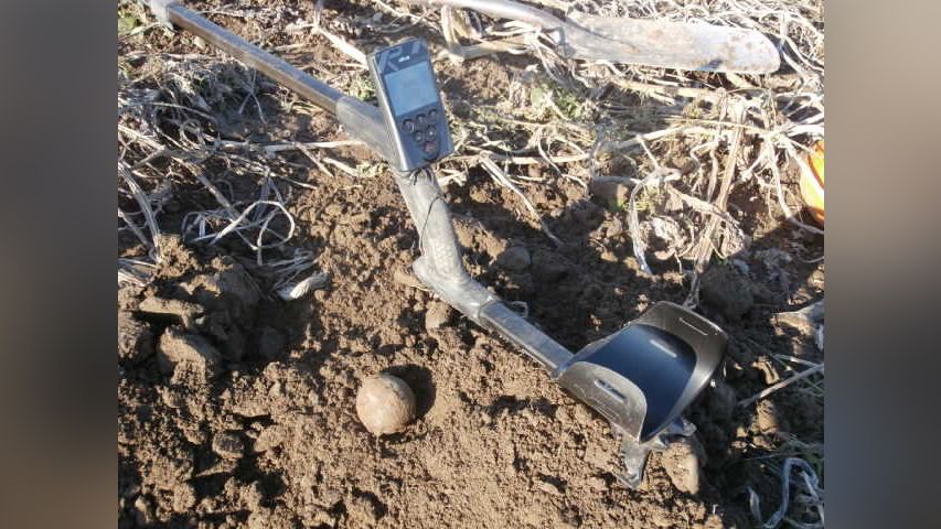 Bailey&nbsp;has unearthed several other metallic items from the&nbsp;late 17th century,&nbsp;including this small 1-pound cannonball&nbsp;(shown here next to his metal detector), which he thinks was used for playing skittles.