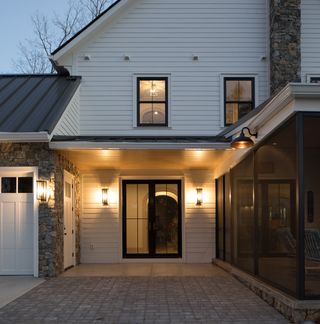 A front door porch with a pendant light shining light downwards