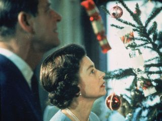 Queen Elizabeth II and Prince Philip look at their decorated Christmas tree during the filming of 'The Royal Family', a joint ITV-BBC television documentary about life in the British royal family.