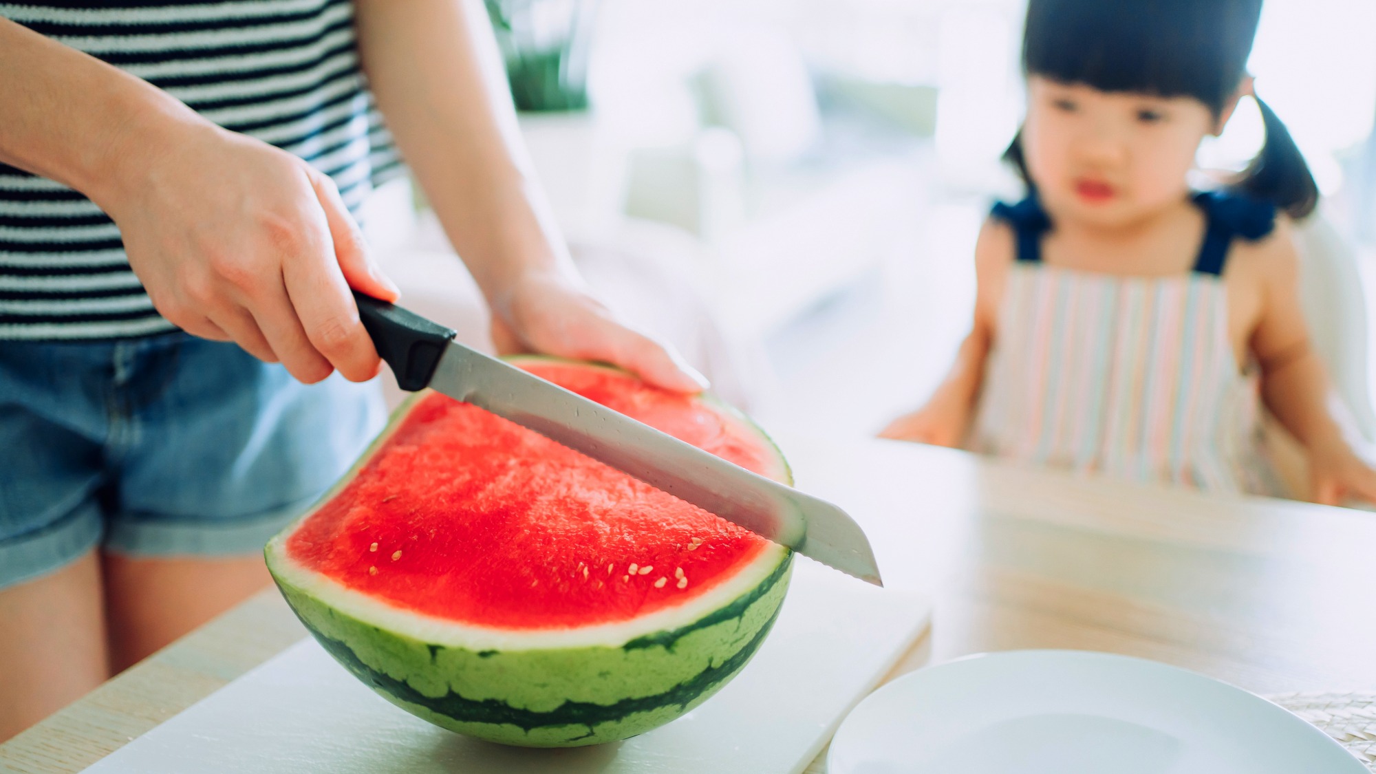 Cutting watermelon for little girl