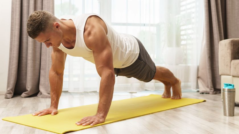 Man performing a push-up on yellow exercise mat at home during workout