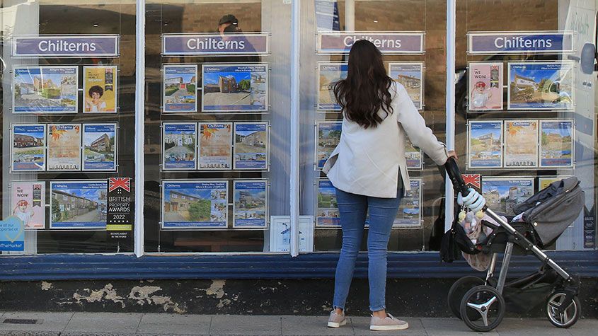 Woman looking in an estate agent&amp;#039;s window