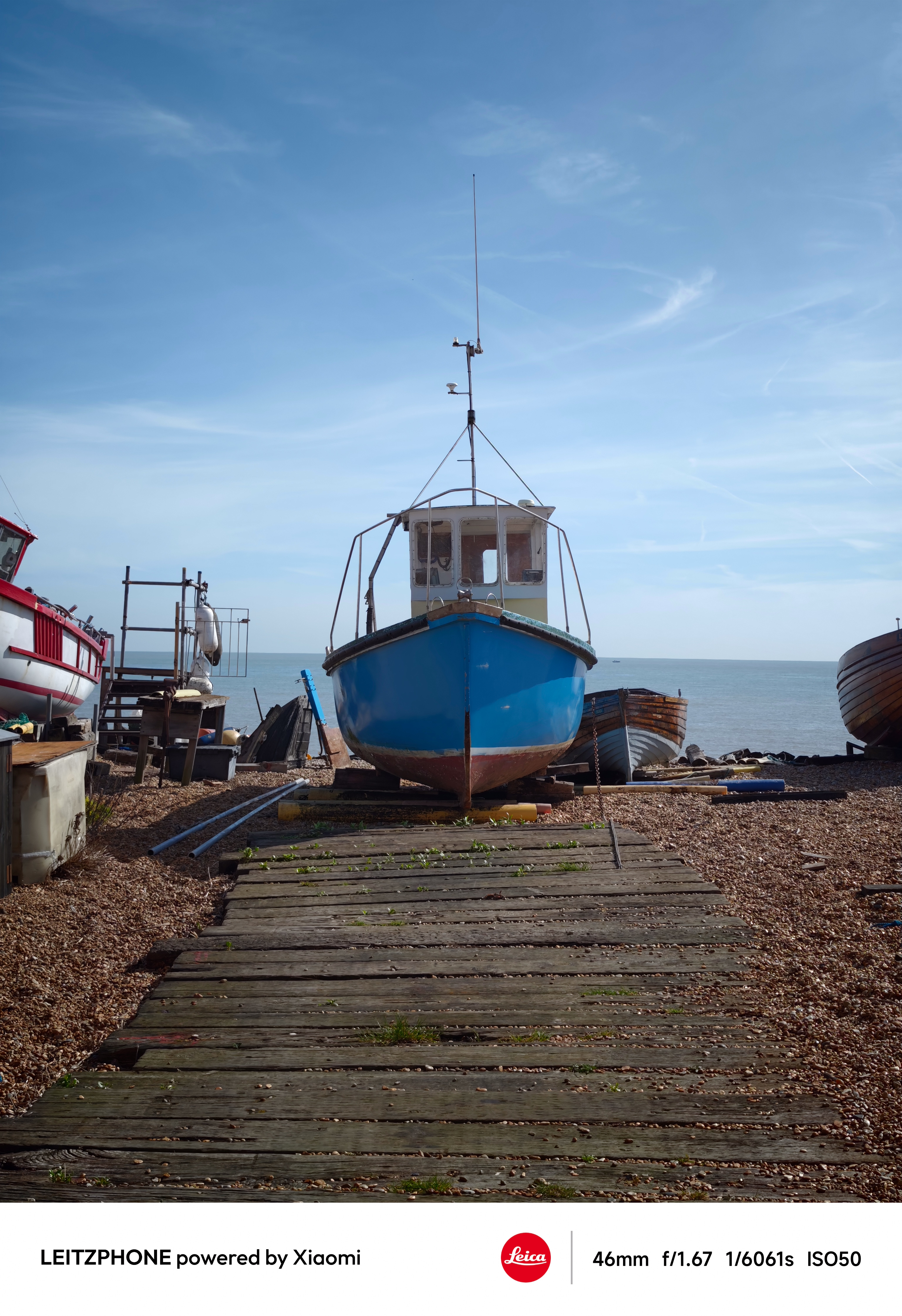 Blue fishing boat viewed head-on by the seafront