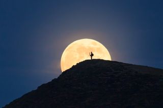 A beautiful bright moon illuminates Brecon Beacons National Park in Wales, UK.