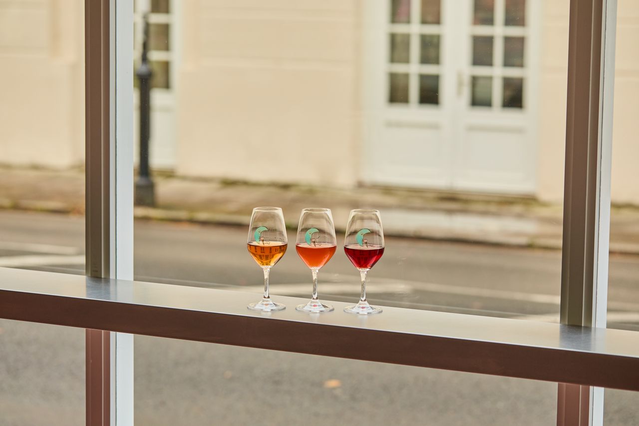 A series of retro-inspired silver ice cream cups and wine glasses are showcased within an ice cream parlor.