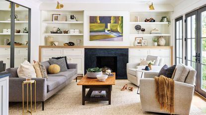 living room with gray sofa and alcove shelves with white walls and steel-framed windows