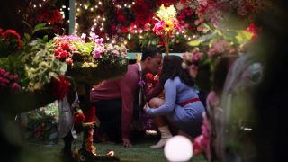 Janine and Gregory kissing in the classroom made of flowers