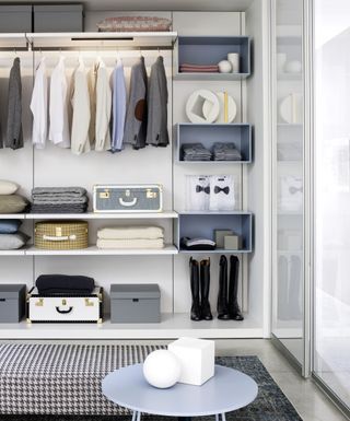 modern walk in closet idea with box shelving, simple hanging rail, trunks, hat boxes, lighting