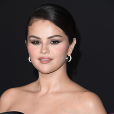 Selena Gomez wearing simple skin-like makeup and diamond hoop earrings.
