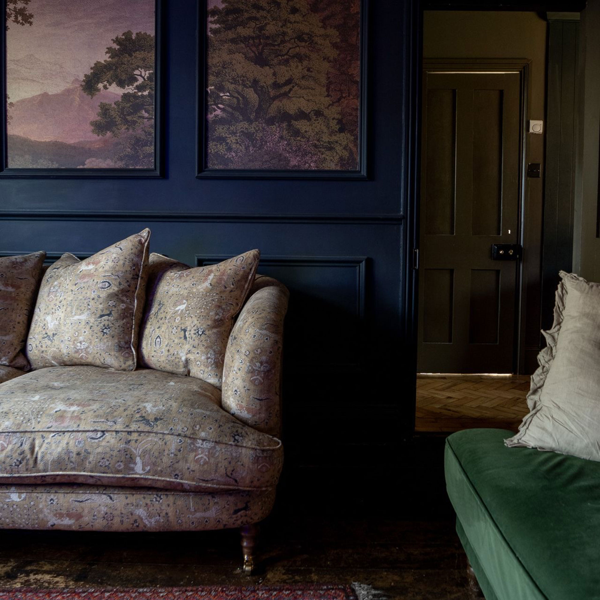 Floral sofa in front of blue panelled wall with nature mural