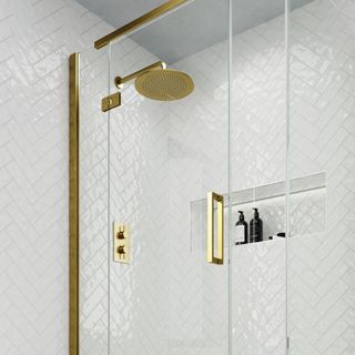 Gold shower in white bathroom with glass shower screen