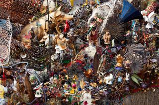 Americana bric-a-brac including glass fruits, metal flowers and ceramic animals adorn swathes of crocheted and beaded blankets