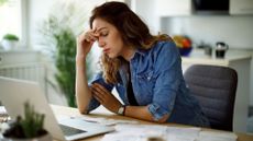 Worried young woman working at home 