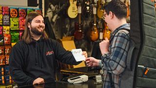 Customer purchasing an acoustic guitar in a guitar store