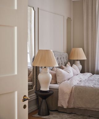 Black and white spotted headboard, white lamps, mirrors