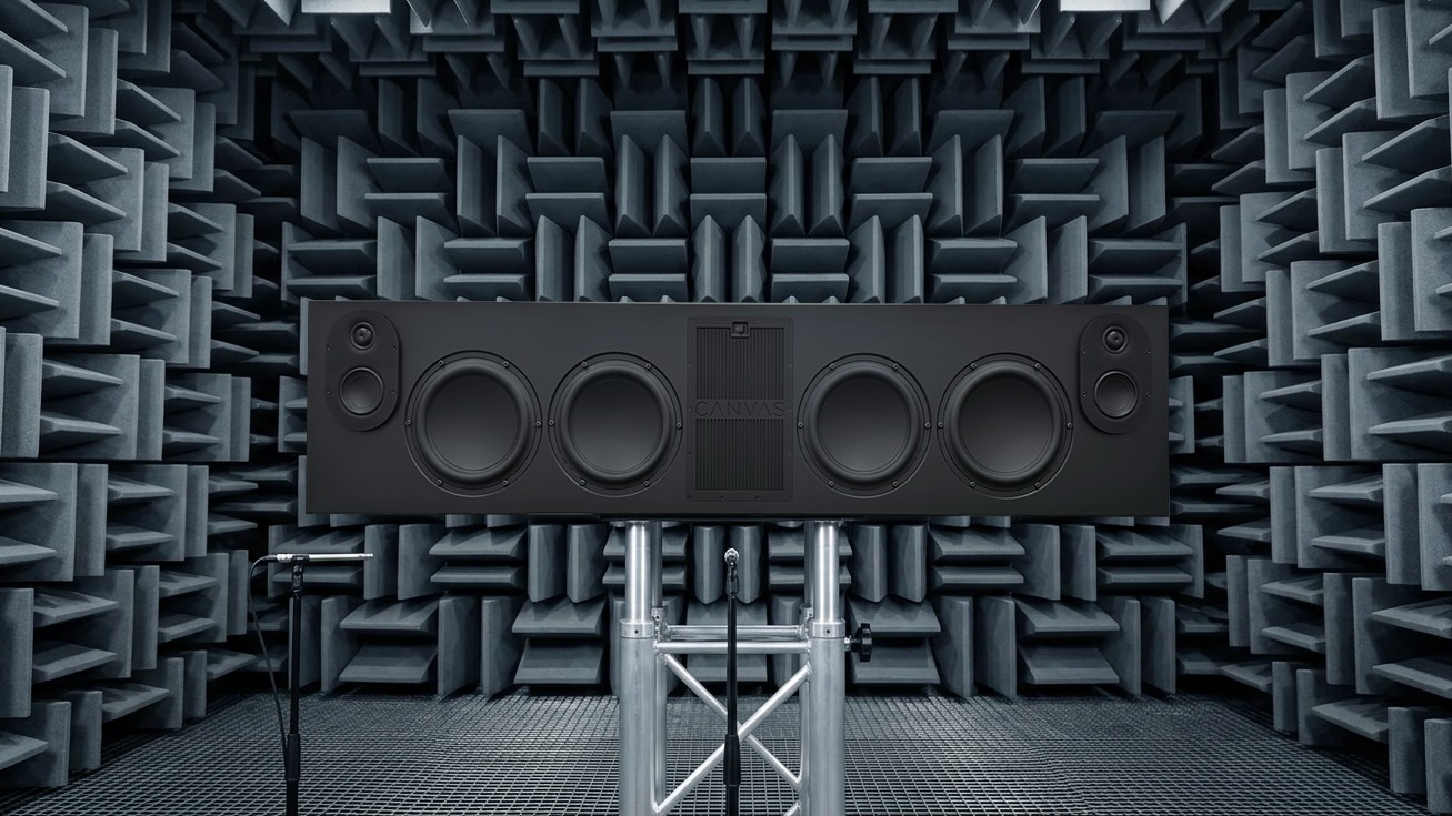 A black Canvas L soundbar in a room with grids all over the walls and ceiling.
