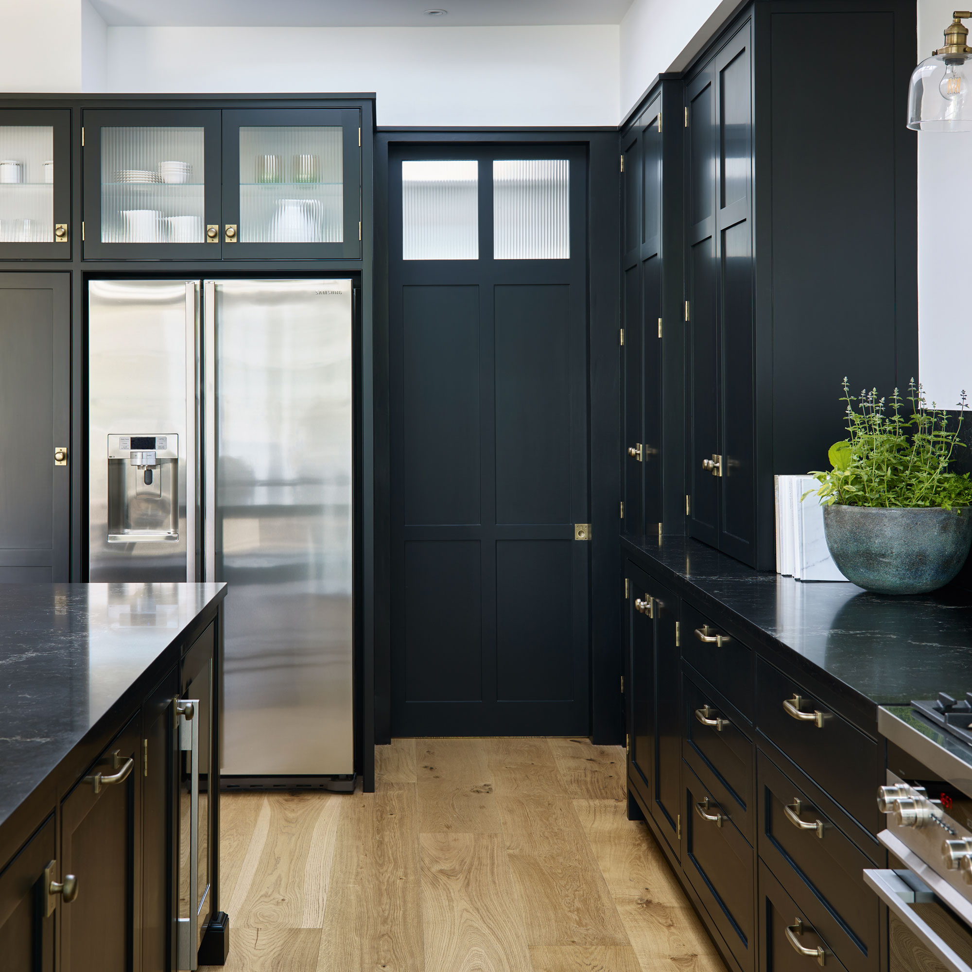 Black kitchen with stainless steel fridge