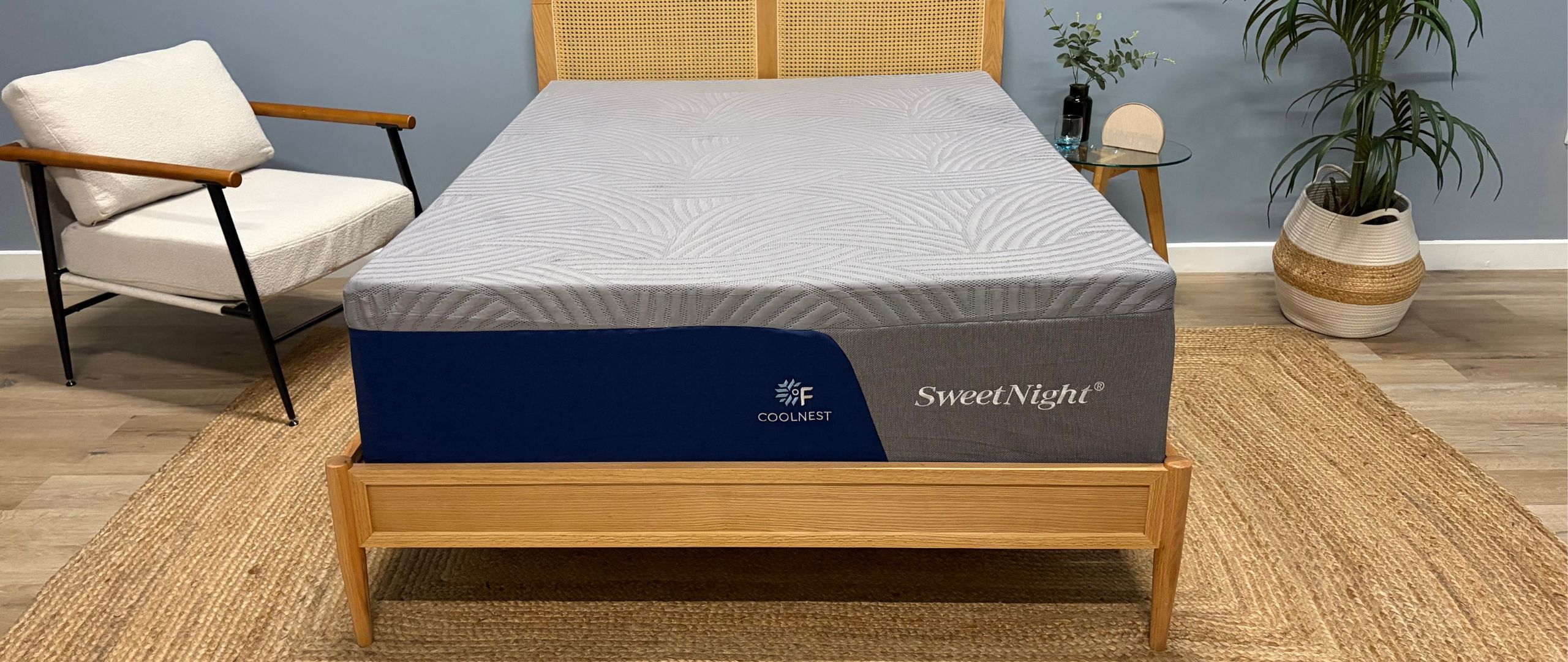 The SweetNight CoolNest on a wooden bedframe in a neutral-colored modern bedroom setting.