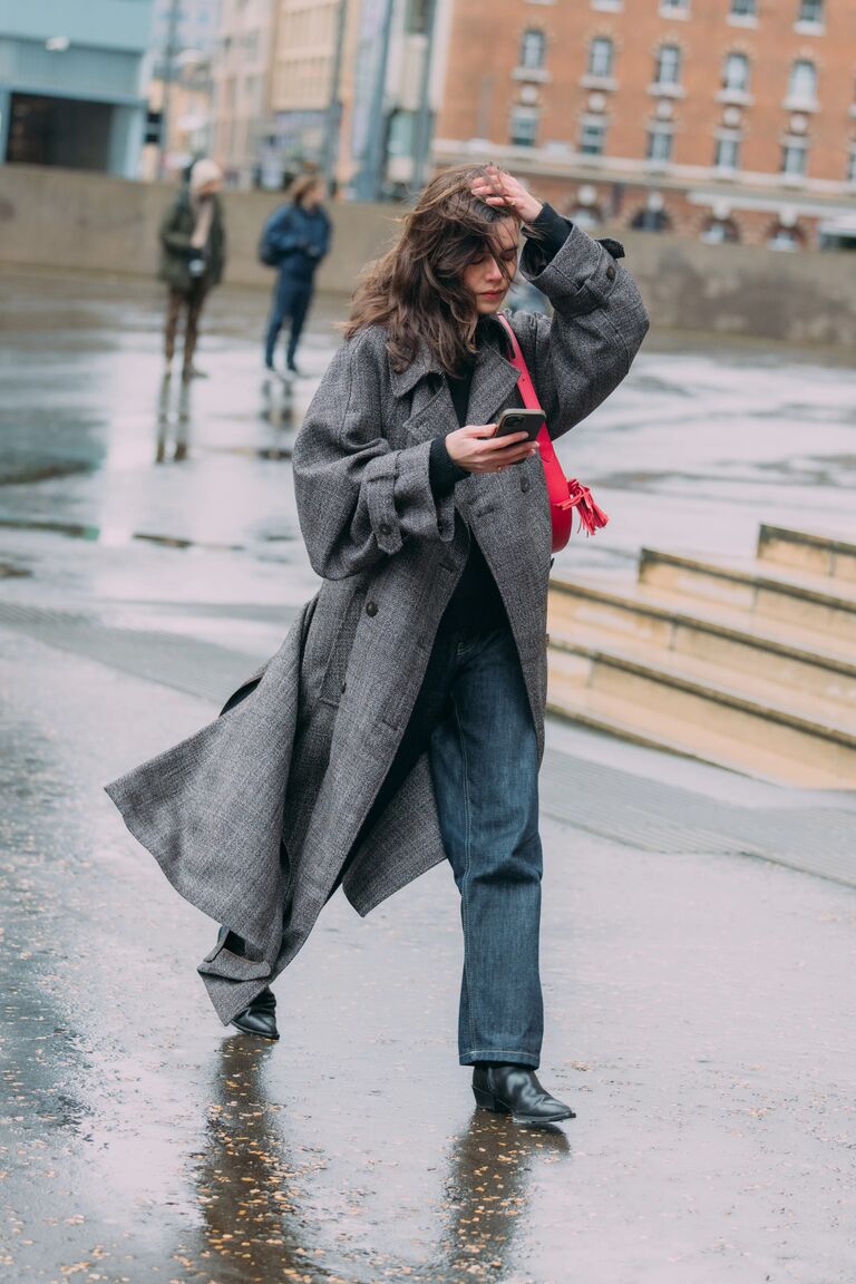 A guest attending shows during London Fashion Week wearing jeans with ankle boots.