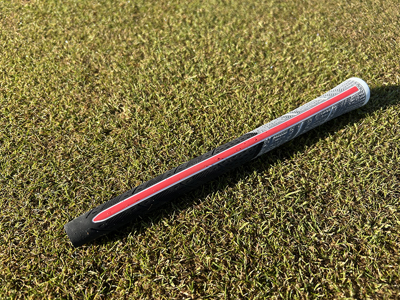 a ribbed golf grip lying on the grass
