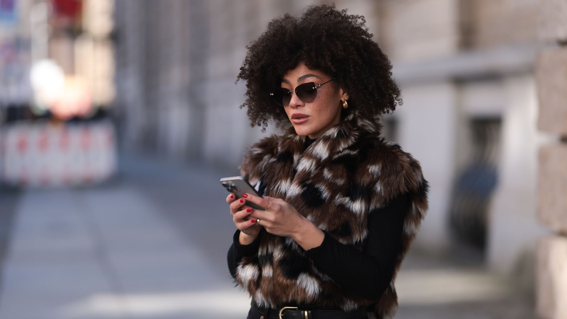 Julia Dalia seen wearing Tiffany &amp;amp; Co silver sunglasses, gold earrings, Arket black wool knit turtleneck sweater, brown / black / white fake fur vest, Levi&amp;rsquo;s black skinny straight leg jeans / pants, S&amp;eacute;zane black / gold belt and Gucci black leather loafers, on February 25, 2024 in Berlin, Germany