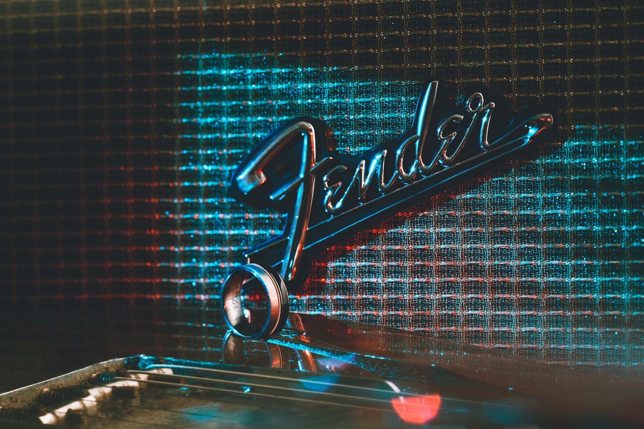Some of Fender's new wedding rings, set against various Fender-themed backdrops