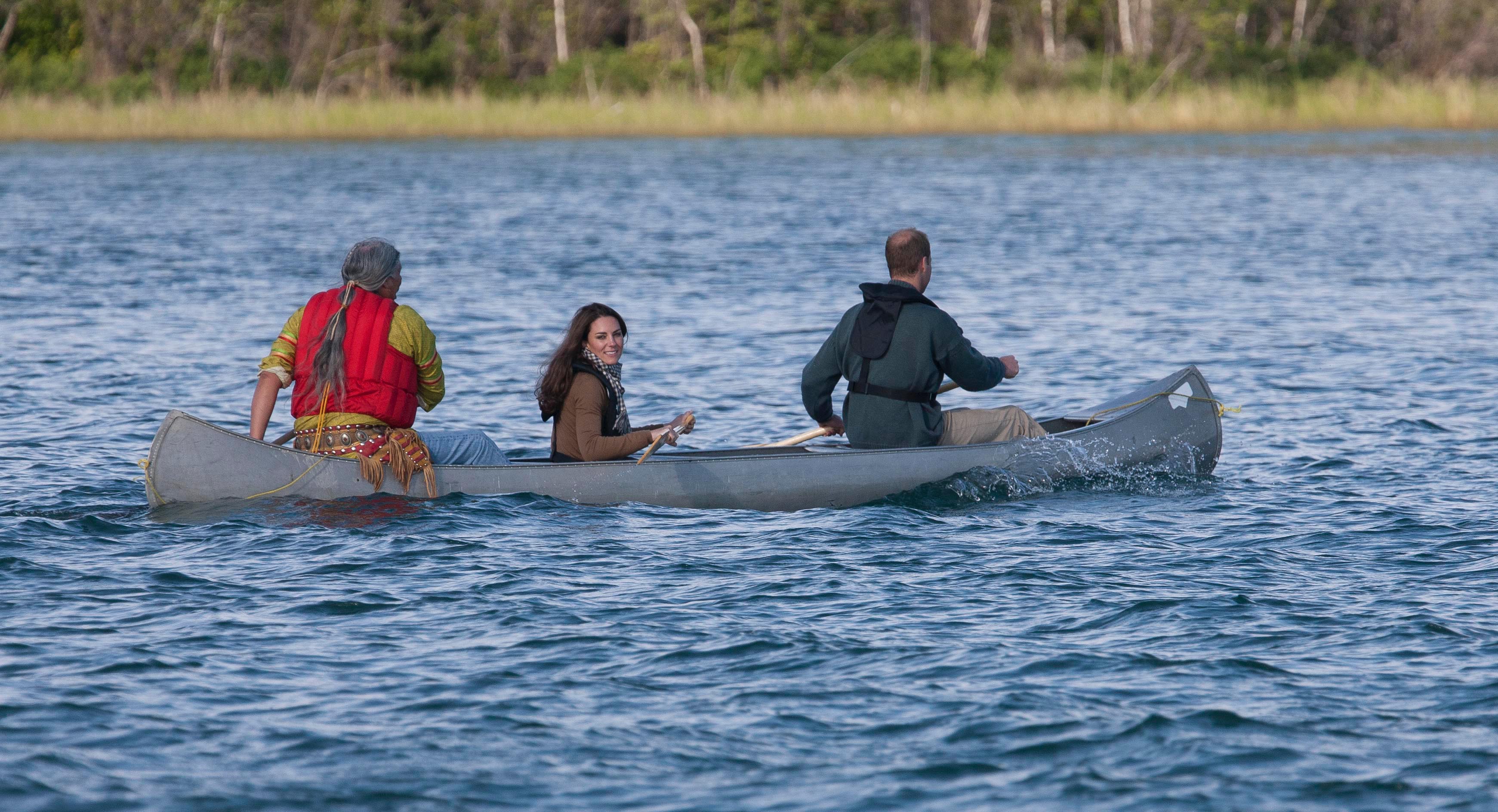 Princess Kate and Prince William paddling a canoe with a man