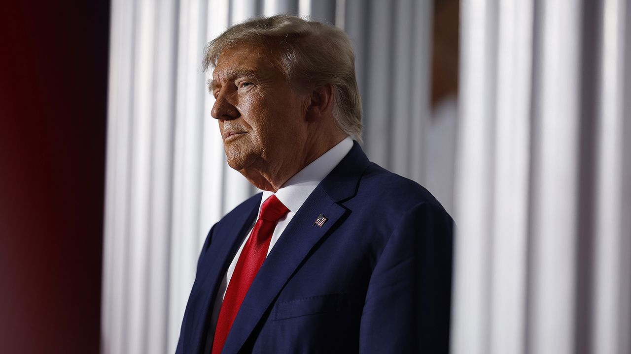 Donald Trump delivers remarks outside the clubhouse at the Trump National Golf Club 