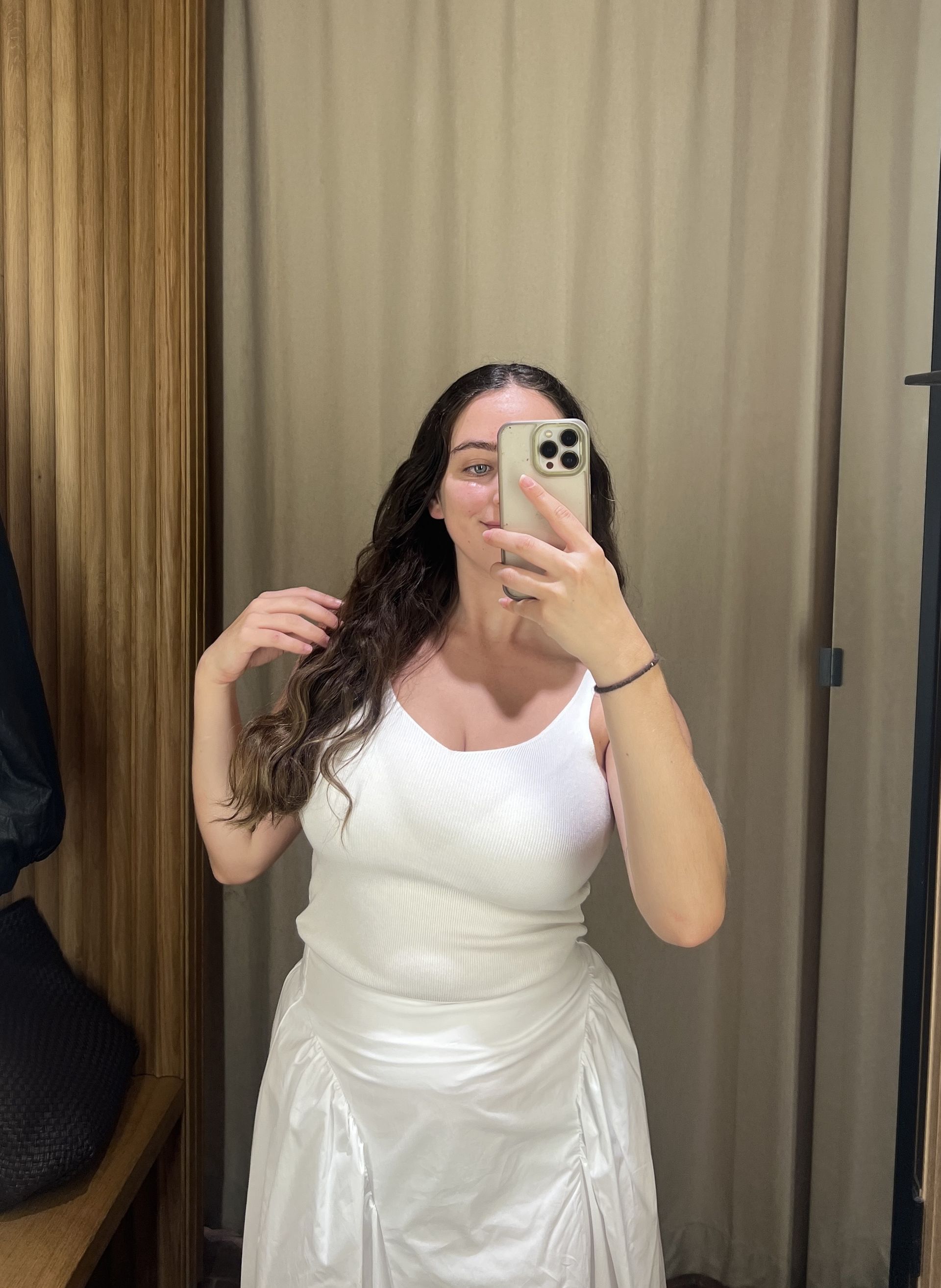 An image of Who What Wear's Ava Gilchrist wearing a Mango white tank top with a white cotton skirt.