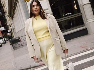 ana wears pale yellow sweater and skirt with beige blazer and white mesh flats