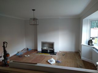 Before shot of lounge with white walls and wood flooring