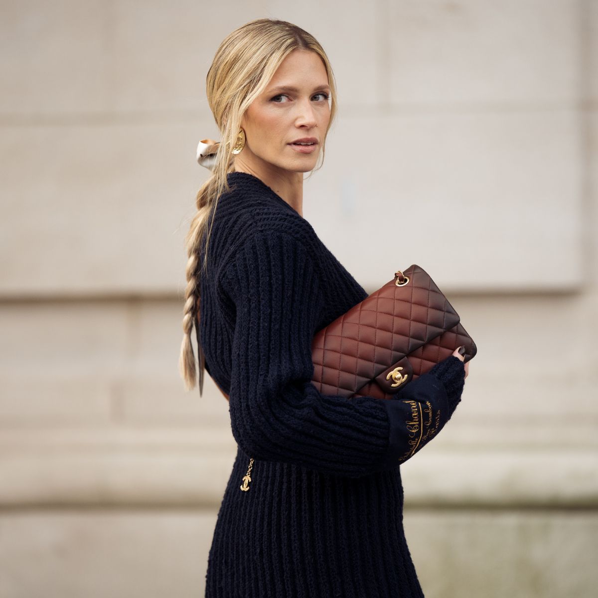 a blonde woman carrying a chanel bag