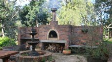 An example of should you build a pizza oven - a large brick pizza oven in a backyard