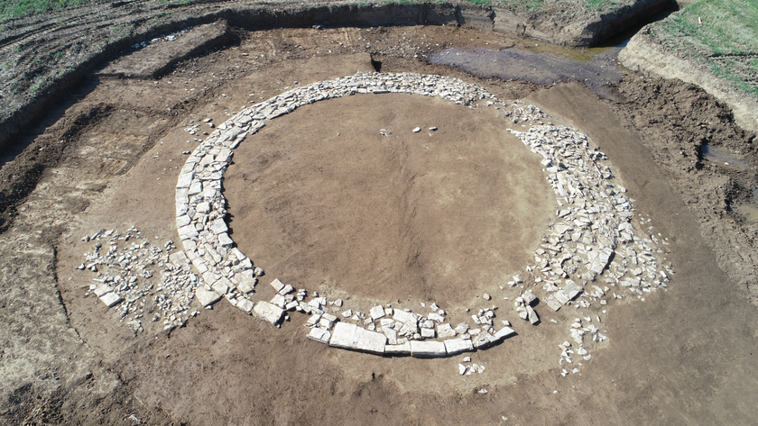 aerial drone shot of a circle of white stones on excavated brown dirt